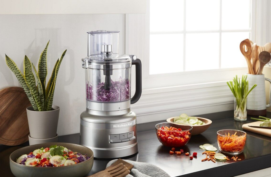 Silver 13-cup food processor on counter with sliced and shredded vegetables Silver 13-cup food processor on counter with sliced and shredded vegetables