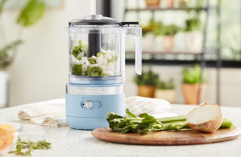 Blue food chopper with chopped celery and onions in bright kitchen Blue food chopper with chopped celery and onions in bright kitchen