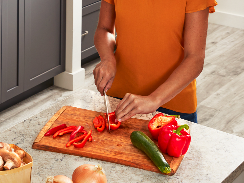 Person slicing bell pepper on a cutting board Person slicing bell pepper on a cutting board
