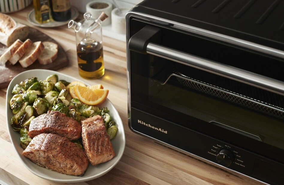 Kitchen counter with a plate of brussels sprouts and salmon next to KitchenAid® countertop oven Kitchen counter with a plate of brussels sprouts and salmon next to KitchenAid® countertop oven