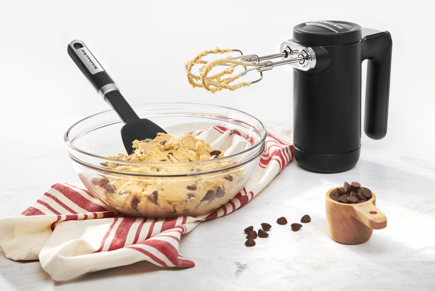 Black KitchenAid® hand mixer with bowl of chocolate chip cookie dough Black KitchenAid® hand mixer with bowl of chocolate chip cookie dough