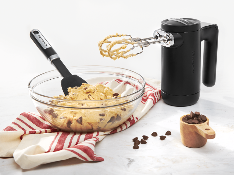 Black KitchenAid® hand mixer with bowl of chocolate chip cookie dough Black KitchenAid® hand mixer with bowl of chocolate chip cookie dough