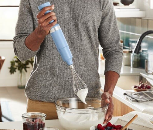 Man whipping cream with immersion blender