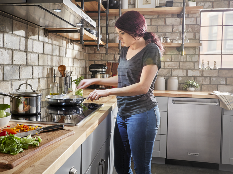Person cooking at a cooktop Person cooking at a cooktop