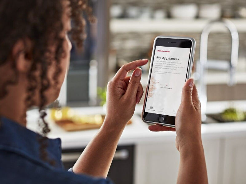 Woman using a smartphone app to control appliances