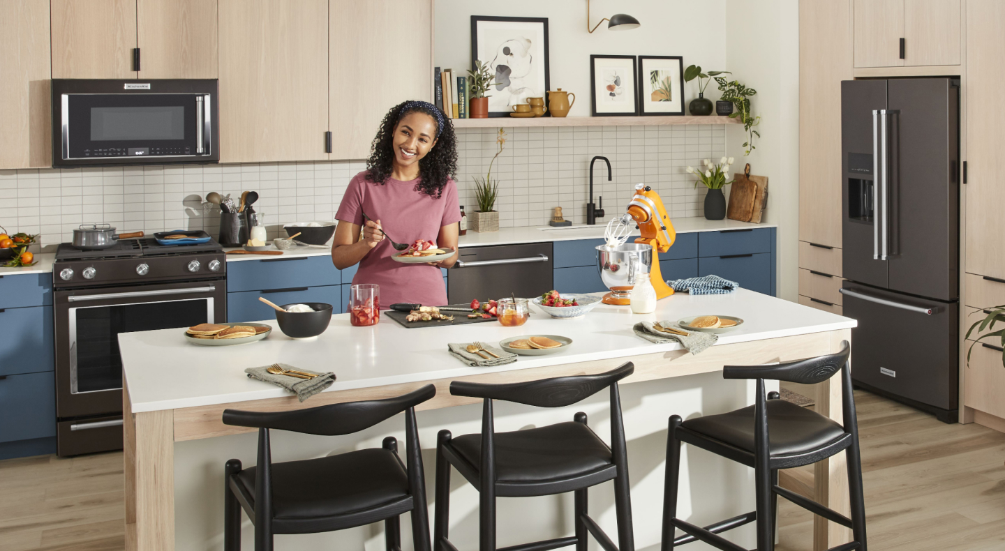 Person preparing place settings at kitchen island Person preparing place settings at kitchen island