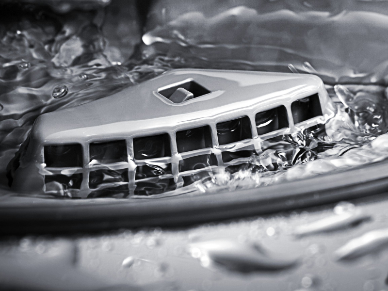 The interior of a KitchenAid® dishwasher releasing water.