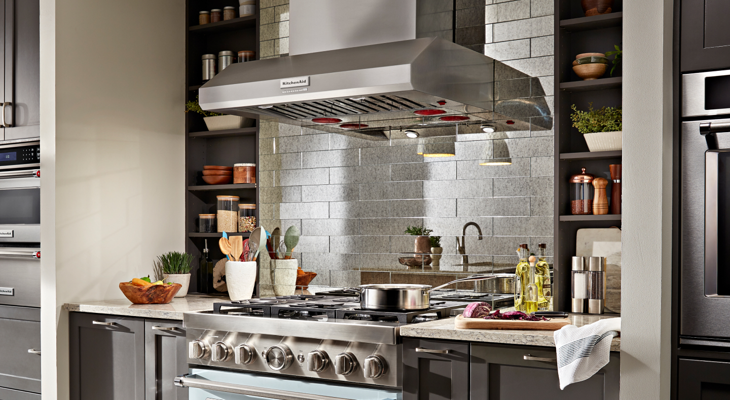 KitchenAid® commercial range hood above gas stovetop with pot on top KitchenAid® commercial range hood above gas stovetop with pot on top