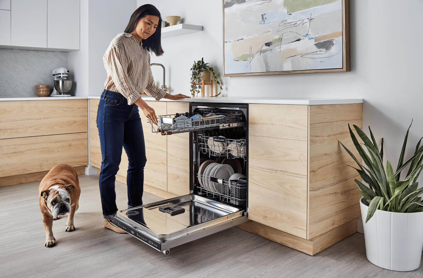 Person loading the third rack of a panel-ready dishwasher  Person loading the third rack of a panel-ready dishwasher