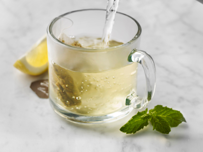 Glass mug of green tea with mint and lemon