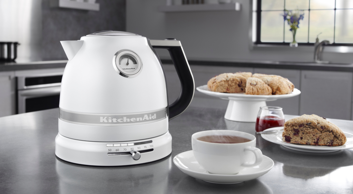 White KitchenAid® electric kettle next to tea and scones