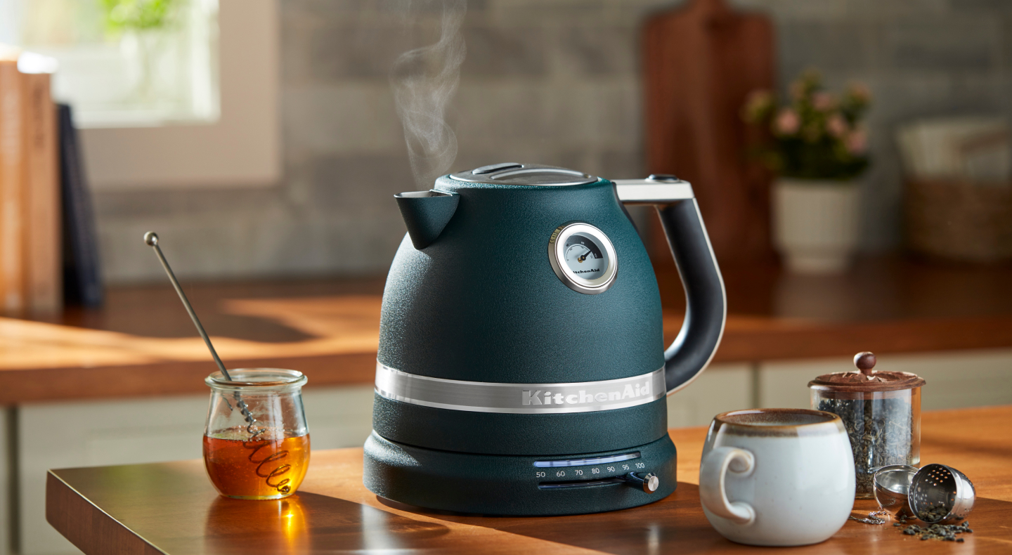 Teal KitchenAid® electric kettle next to tea and honey Teal KitchenAid® electric kettle next to tea and honey