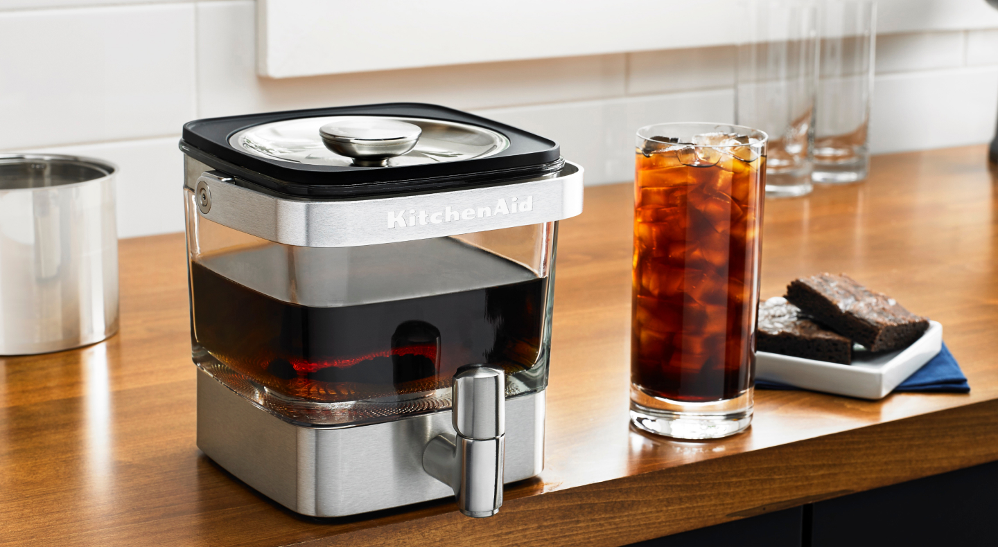 KitchenAid® cold brew maker next to a glass of iced tea