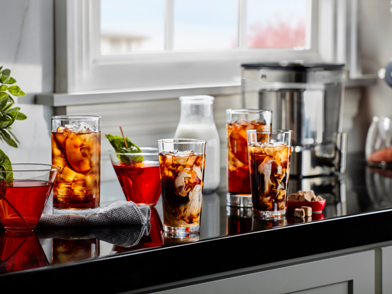Glasses of iced black tea with peach slices and iced herbal tea with mint garnishes Glasses of iced black tea with peach slices and iced herbal tea with mint garnishes