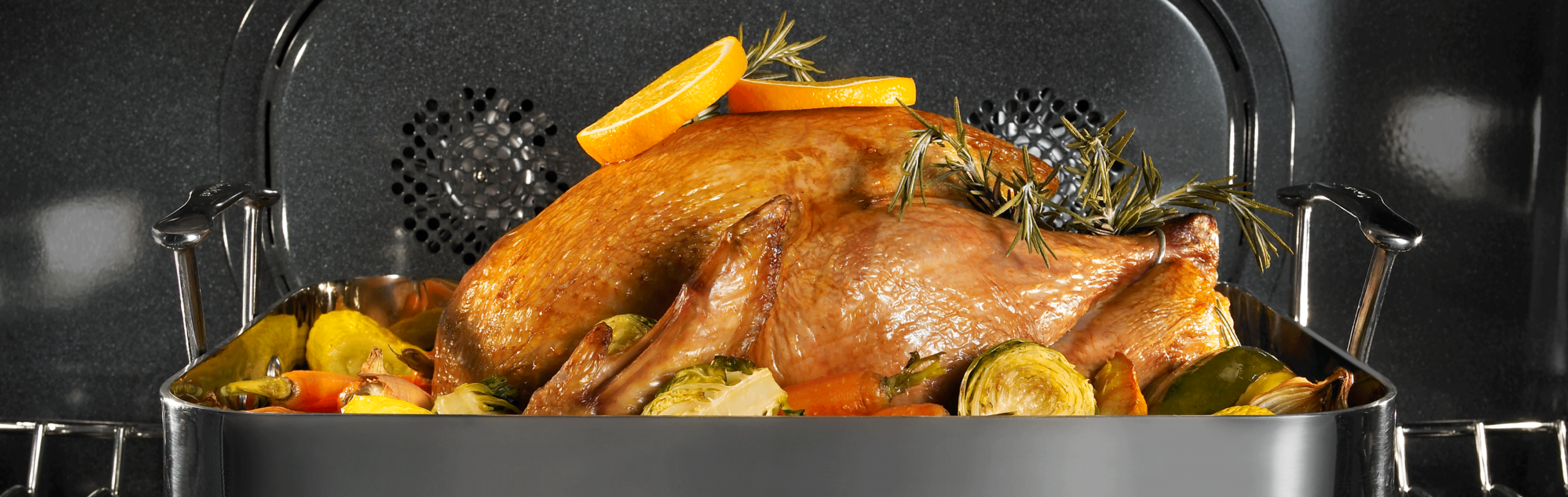 Full turkey in an oven seasoned with herbs and vegetables
