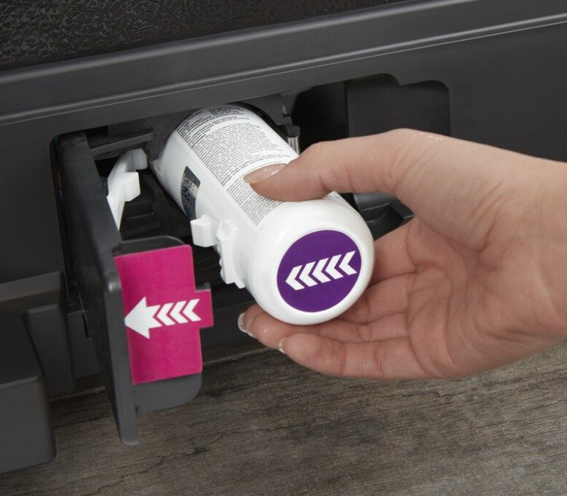 Hand removing an old water filter from a refrigerator