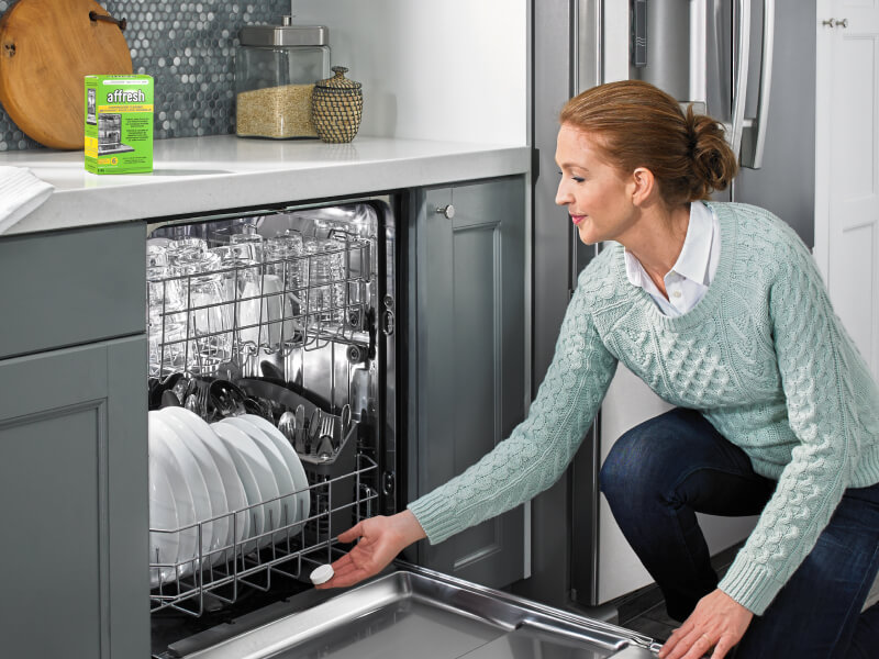 A person using an affresh® dishwasher cleaner tablet to clean their dishwasher A person using an affresh® dishwasher cleaner tablet to clean their dishwasher