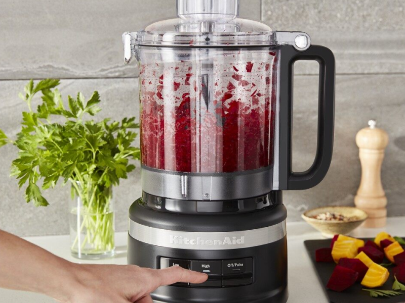 A person using a KitchenAid® food processor to process fresh ingredients A person using a KitchenAid® food processor to process fresh ingredients