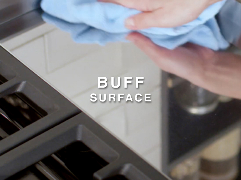 Person wiping griddle with clean microfiber cloth