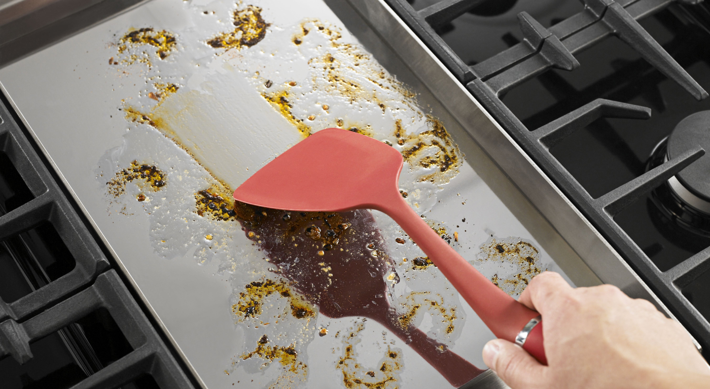 Person spreading grease with a spatula Person spreading grease with a spatula