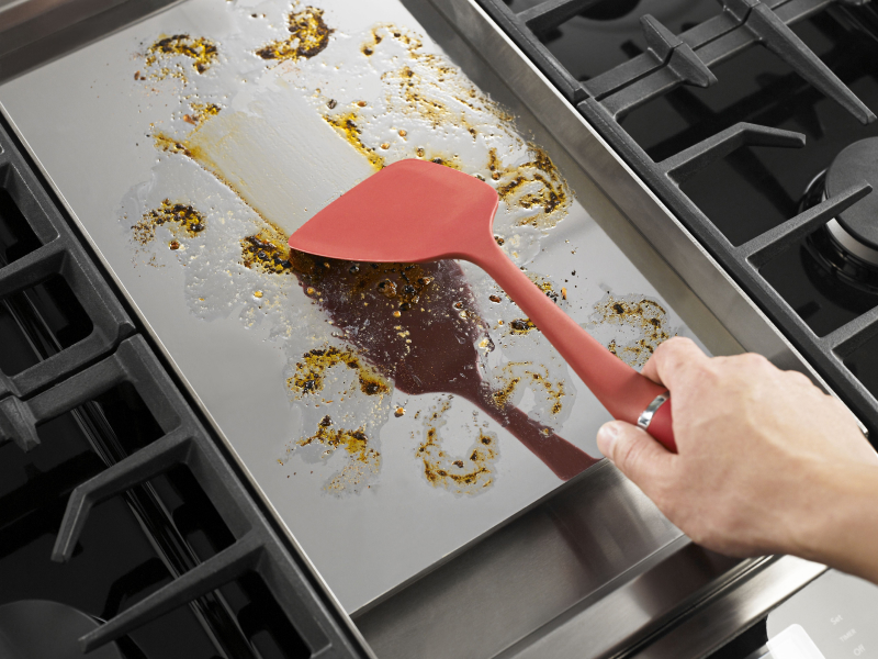 Person spreading grease with a spatula Person spreading grease with a spatula
