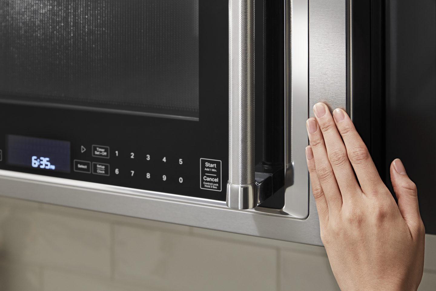 Hand closing a KitchenAid® over the range microwave Hand closing a KitchenAid® over the range microwave