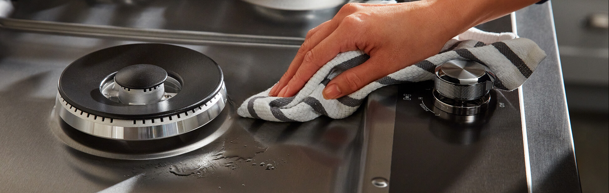 Person wiping a stovetop
