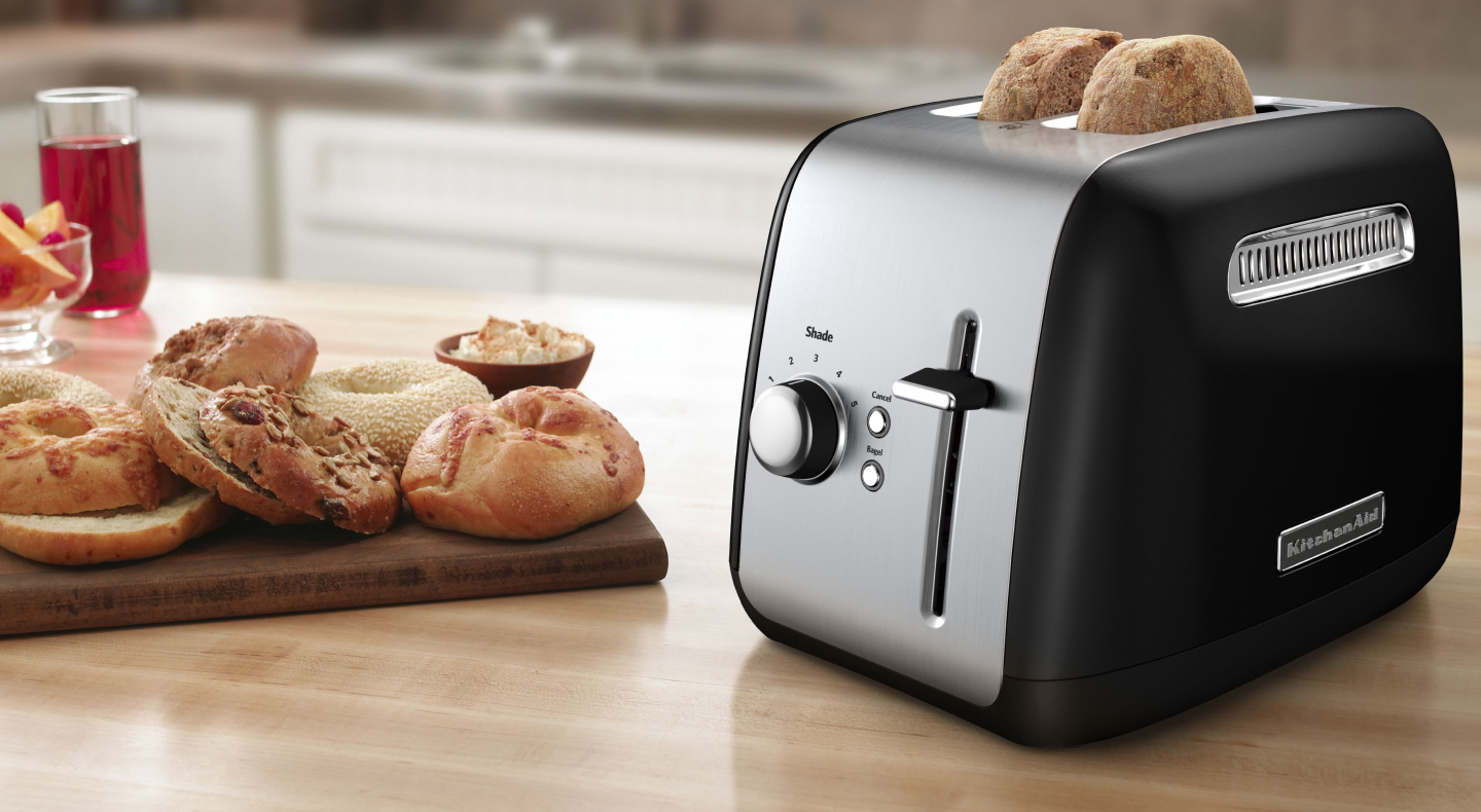 Bagel slices in a silver KitchenAid® toaster on a modern kitchen counter. Bagel slices in a silver KitchenAid® toaster on a modern kitchen counter.