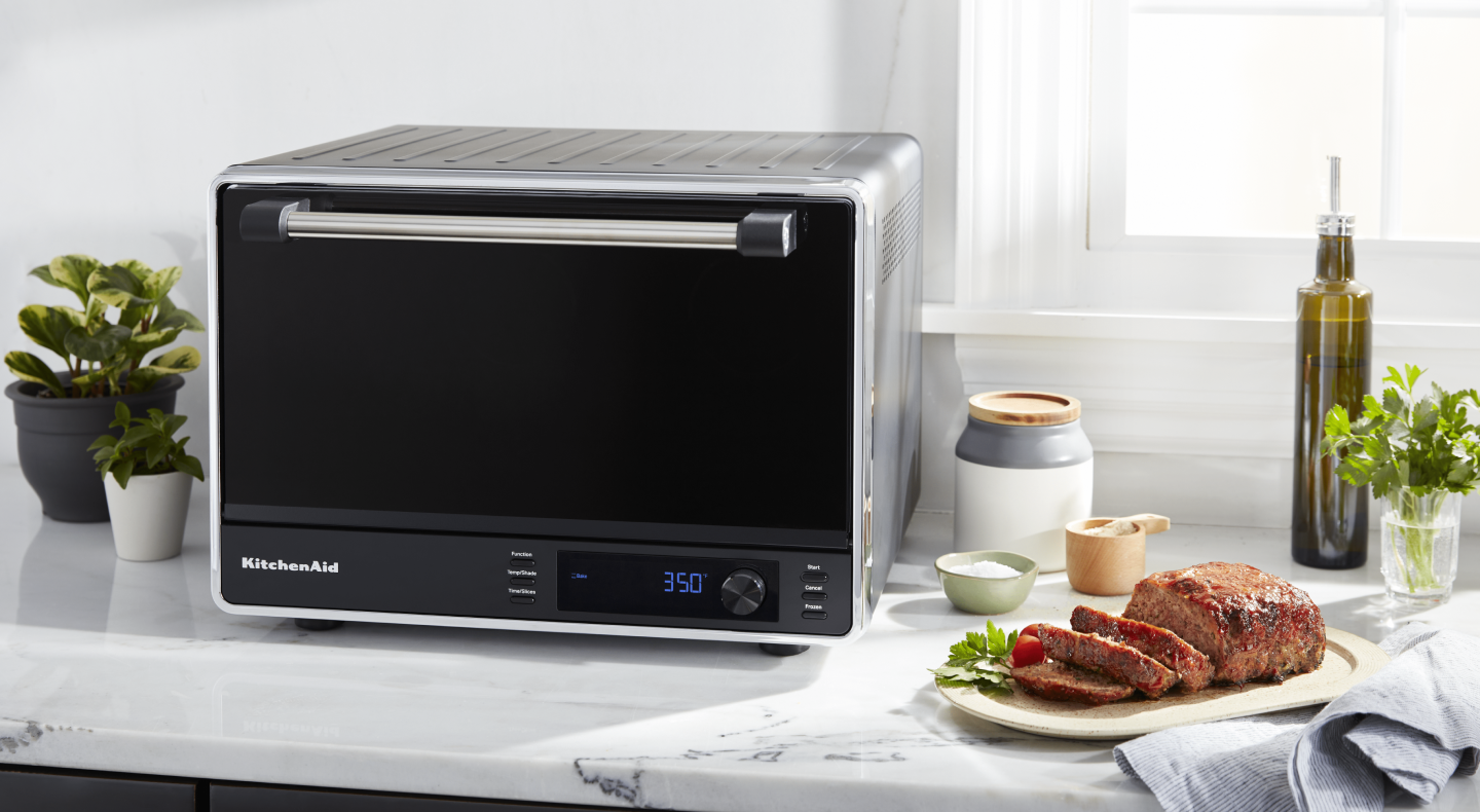 Cooked meat next to a black KitchenAid® countertop oven Cooked meat next to a black KitchenAid® countertop oven
