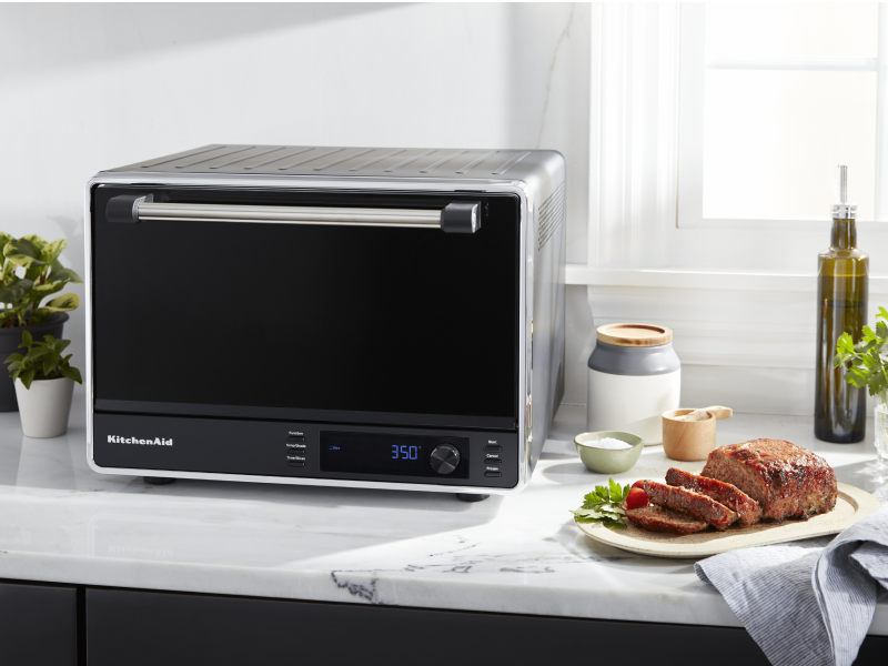 Cooked meat next to a black KitchenAid® countertop oven Cooked meat next to a black KitchenAid® countertop oven