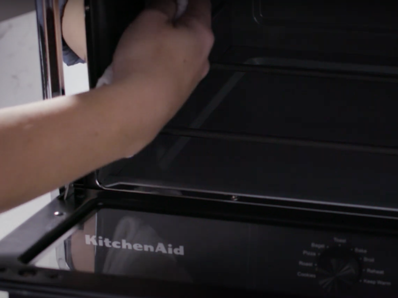 A person cleaning the interior of an air fryer