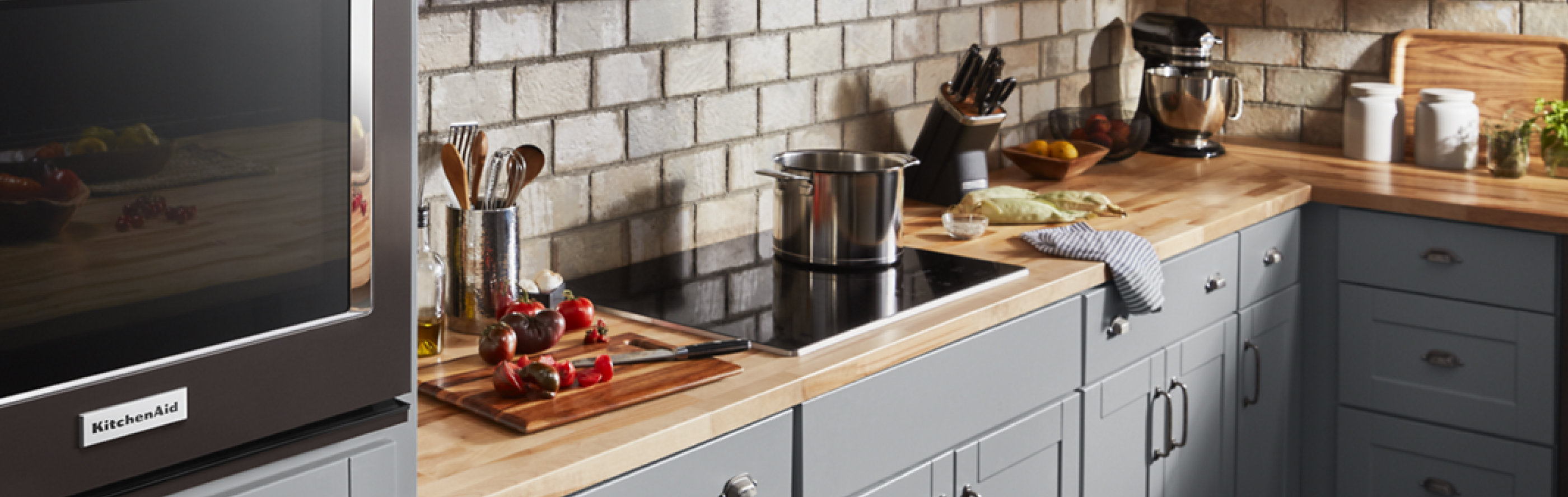 Sliced vegetables next to a black KitchenAid® induction cooktop