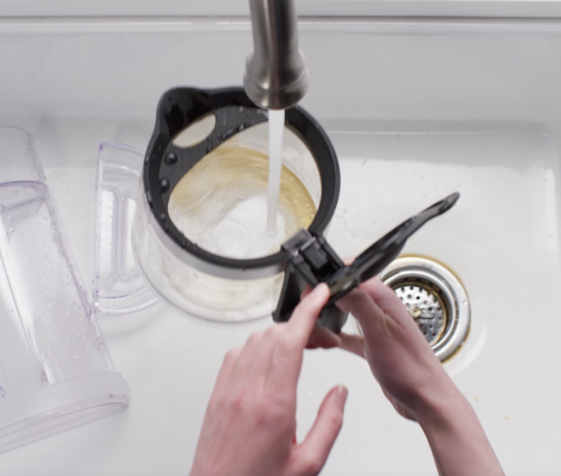 Drip coffee maker parts being cleaned in soapy water