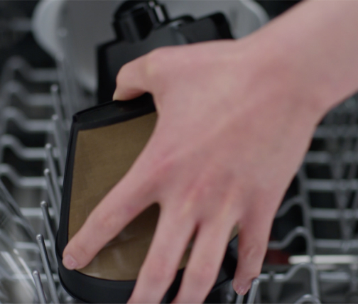 Dishwasher-safe coffee maker parts going into a dishwasher