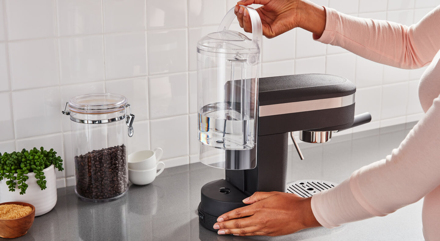 Hand removing the water tank of a KitchenAid® espresso machine Hand removing the water tank of a KitchenAid® espresso machine