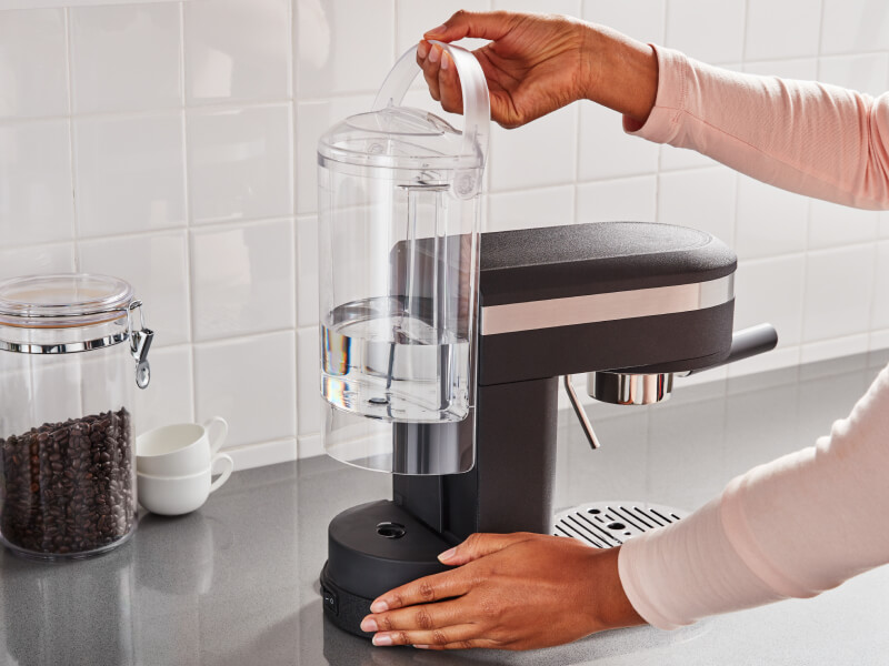 Hand removing the water tank of a KitchenAid® espresso machine Hand removing the water tank of a KitchenAid® espresso machine