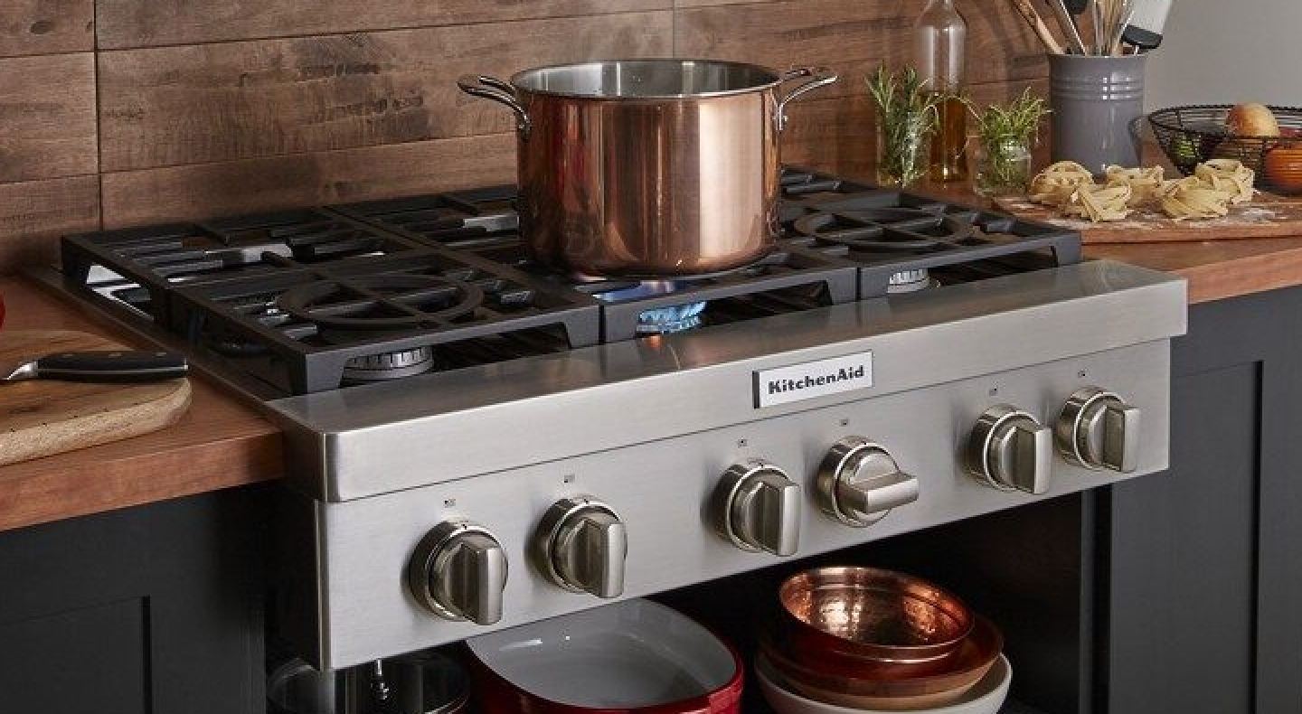 A large pot sitting on an activated KitchenAid® stovetop burner A large pot sitting on an activated KitchenAid® stovetop burner