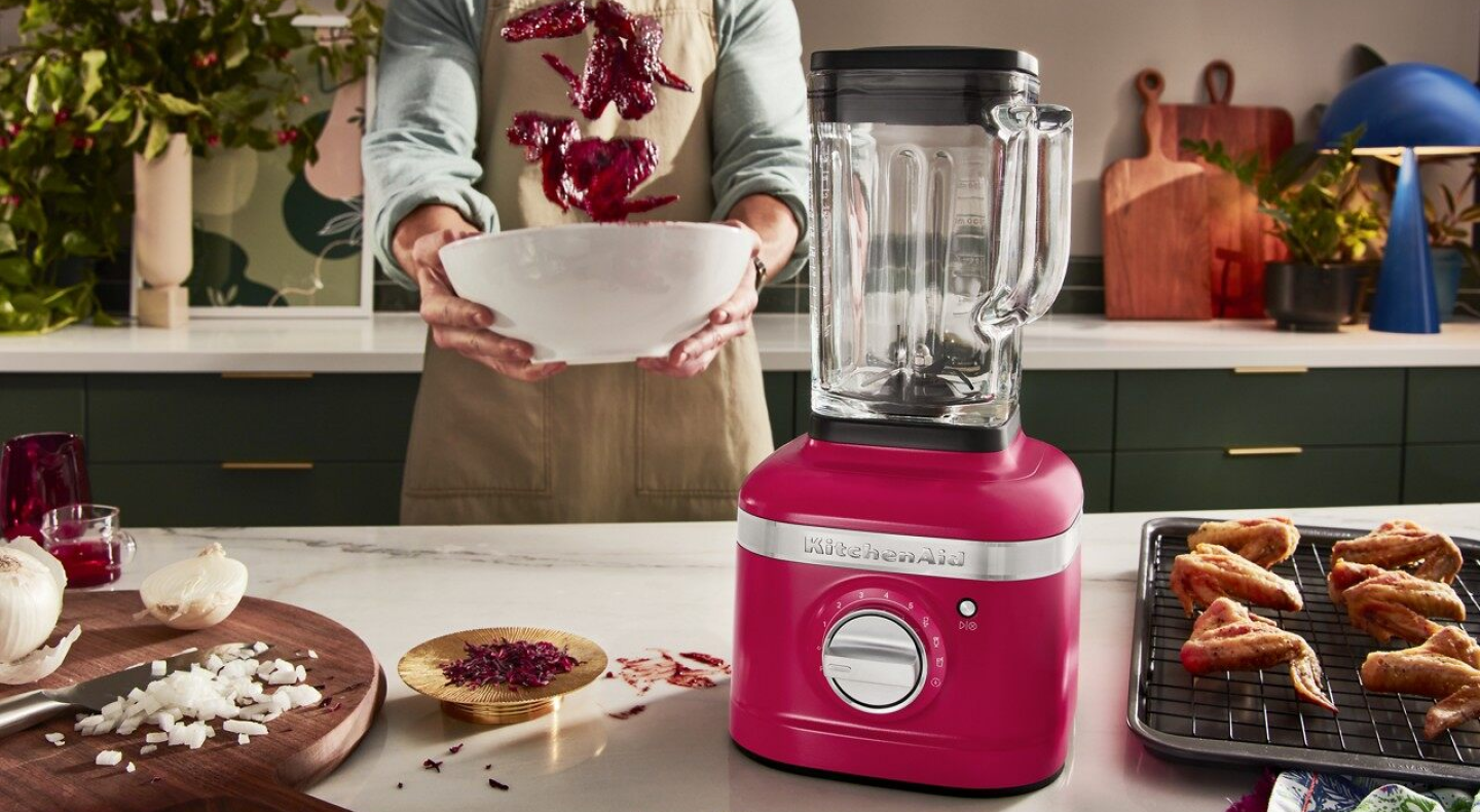 A person tossing wings in a glaze