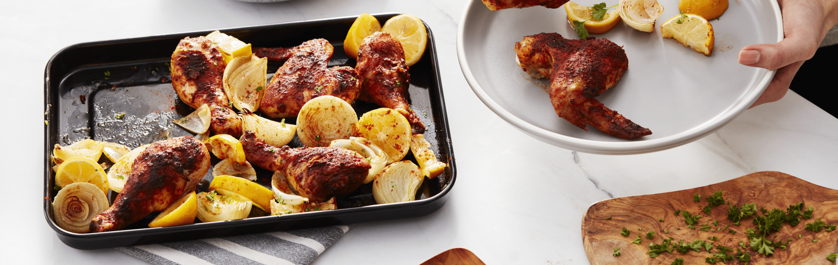Sheet pan of roasted chicken wings and lemon wedges