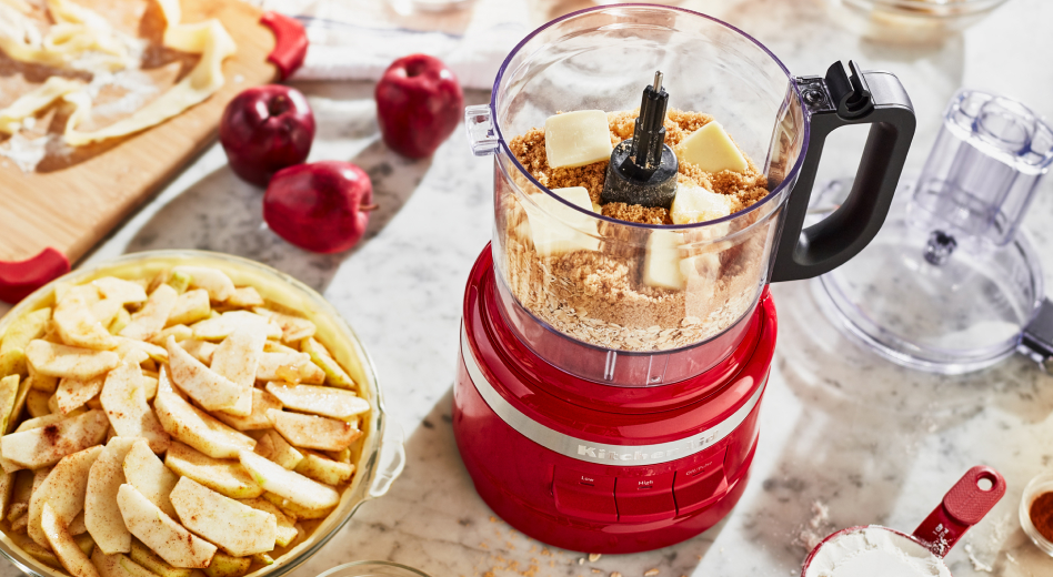 Bowl of apple slices and food processor filled with flour and cubes of butter Bowl of apple slices and food processor filled with flour and cubes of butter
