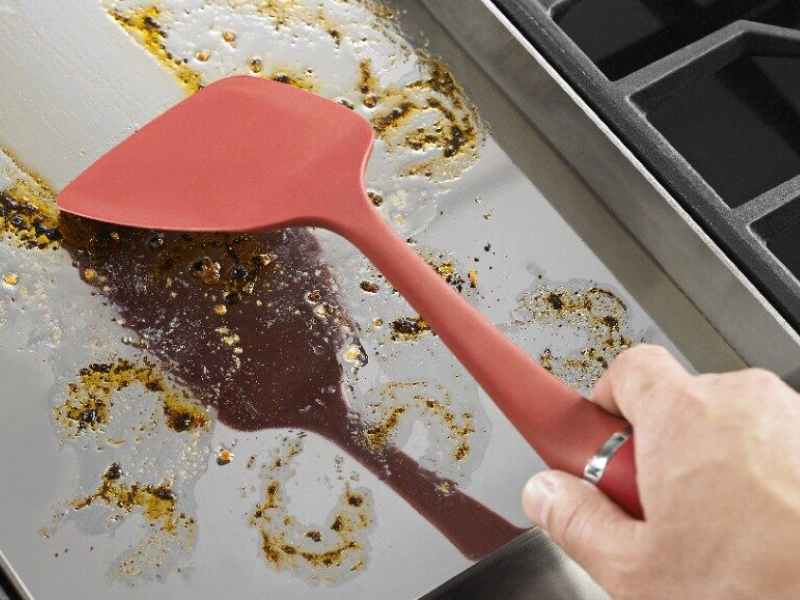 Spatula cleaning a baking sheet