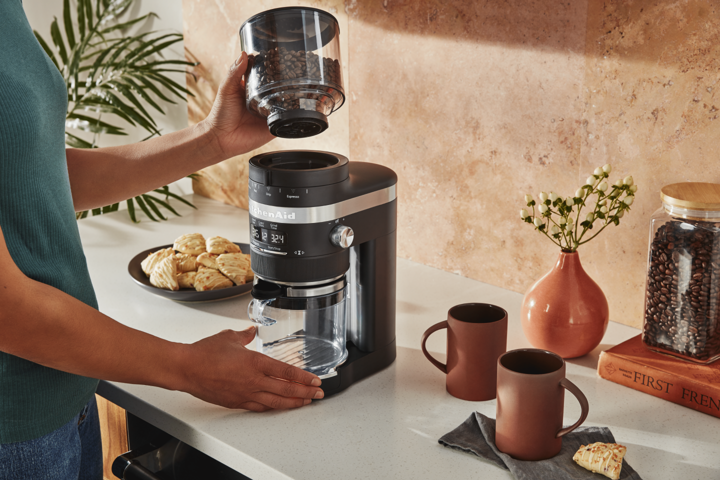Woman placing top of coffee grinder on base of grinder Woman placing top of coffee grinder on base of grinder