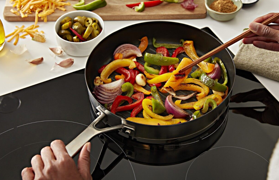 Veggies stir frying on an electric cooktop Veggies stir frying on an electric cooktop