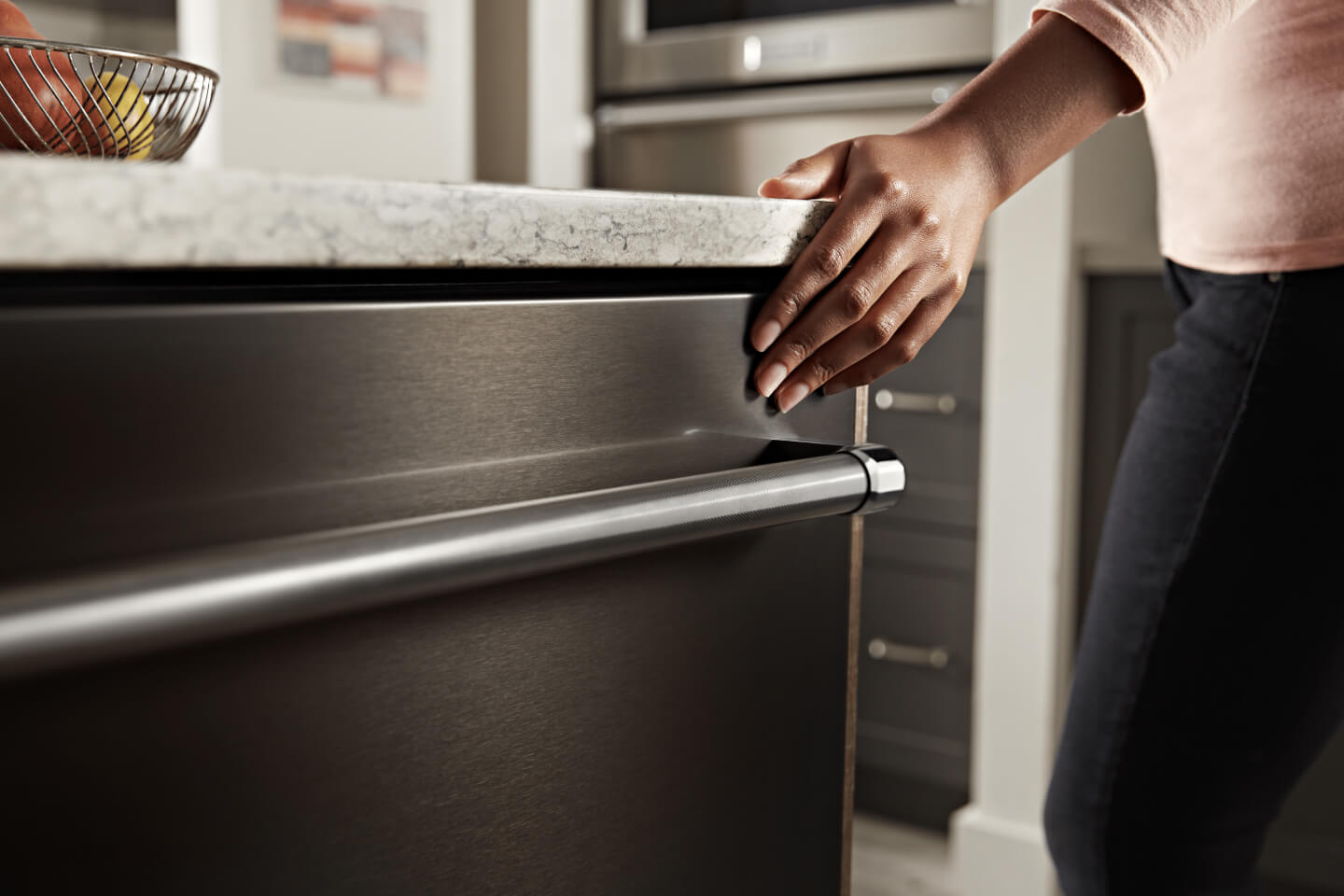 Person closing a KitchenAid® top control dishwasher Person closing a KitchenAid® top control dishwasher