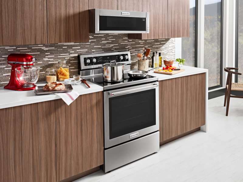 A stainless steel KitchenAid® slide-in range next to prepared dishes  A stainless steel KitchenAid® slide-in range next to prepared dishes