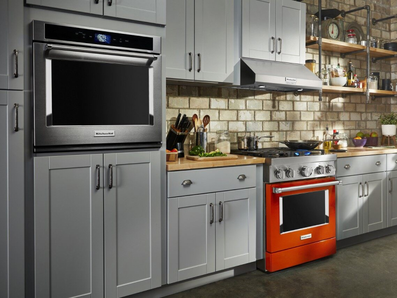 Burnt orange KitchenAid® commercial-style range and KitchenAid® single wall oven in gray cabinetry