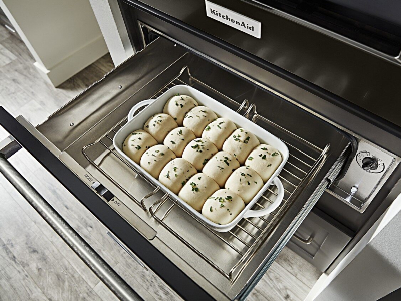 Seasoned roll dough rising in a warming drawer