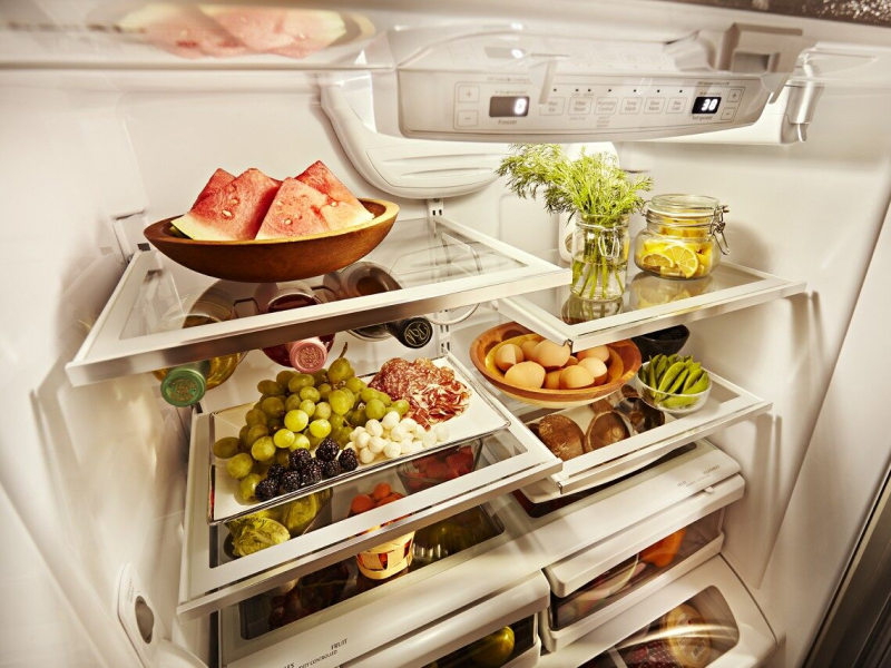 Prepared entrees and appetizers on serving dishes inside a refrigerator