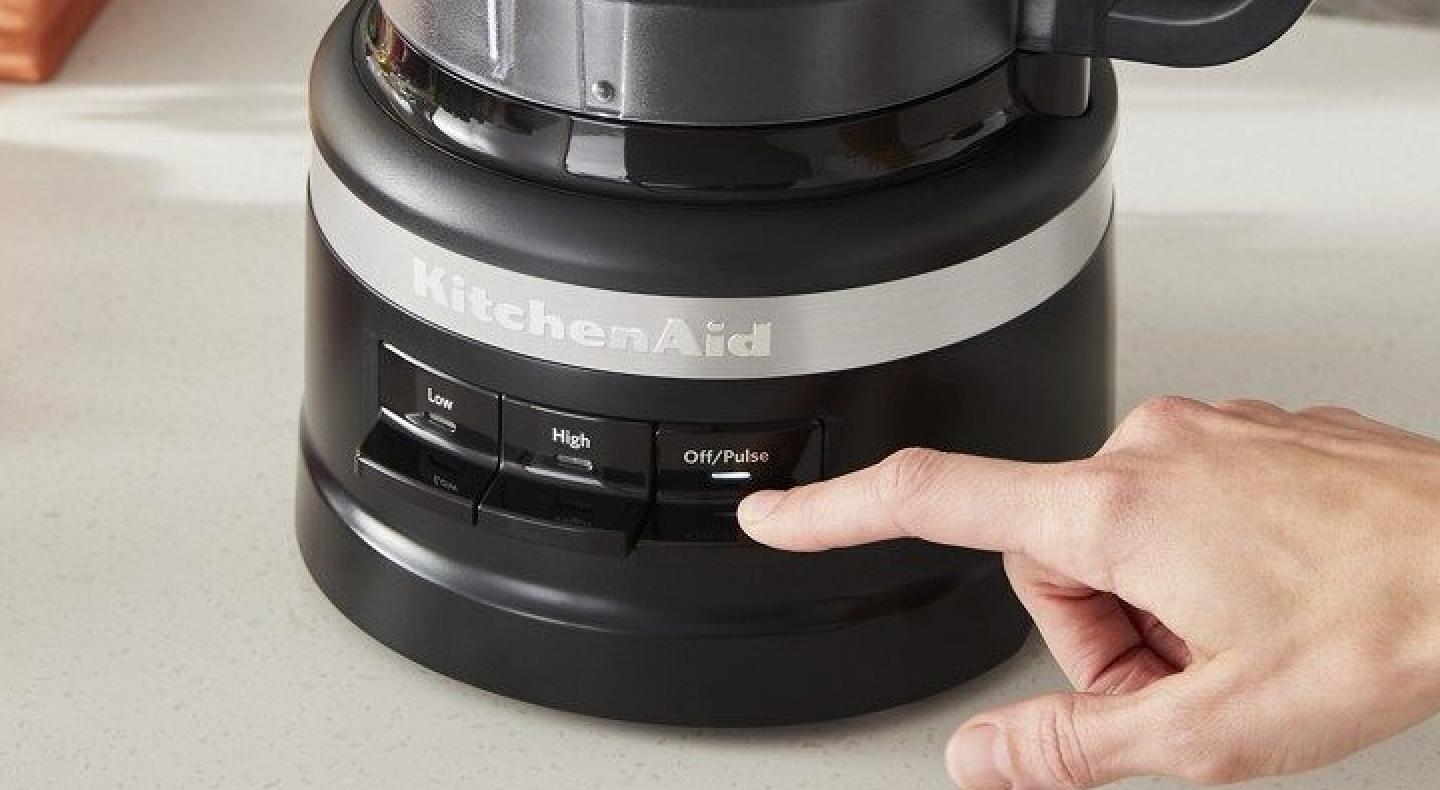 Hand pressing pulse button on a food processor Hand pressing pulse button on a food processor