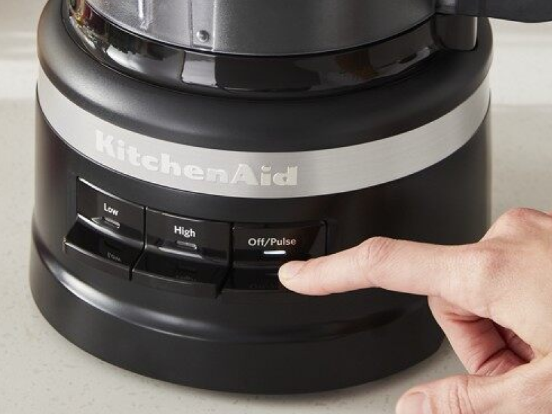 Hand pressing pulse button on a food processor Hand pressing pulse button on a food processor